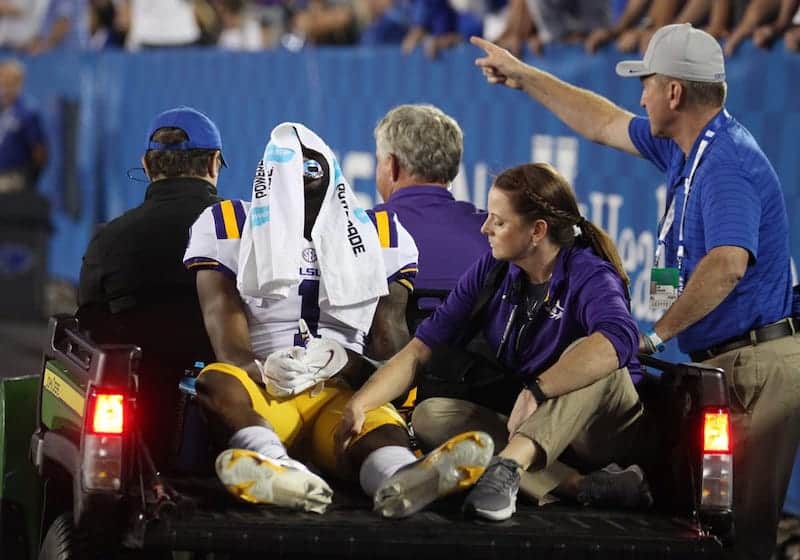 a football player assisted by his team