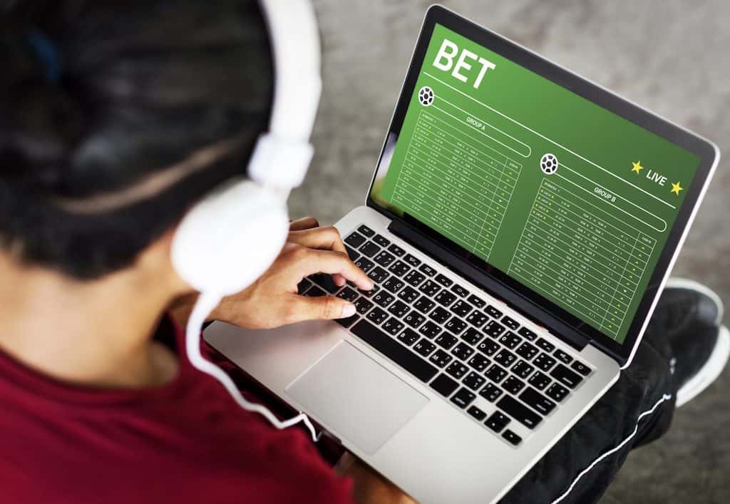 a sports bettor using his computer